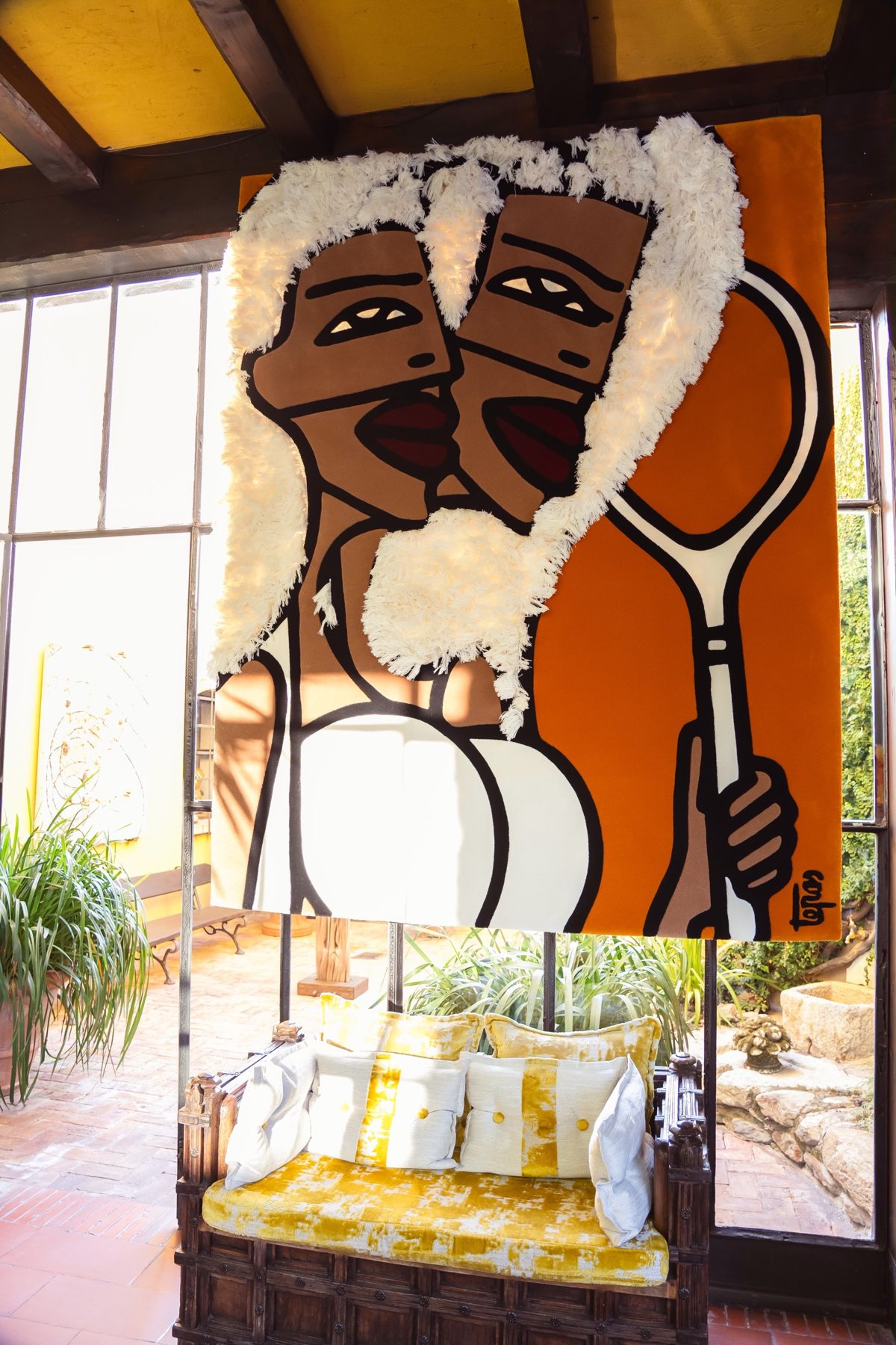 Textile artwork of two figures with a tennis racket, donated for the CWF art auction