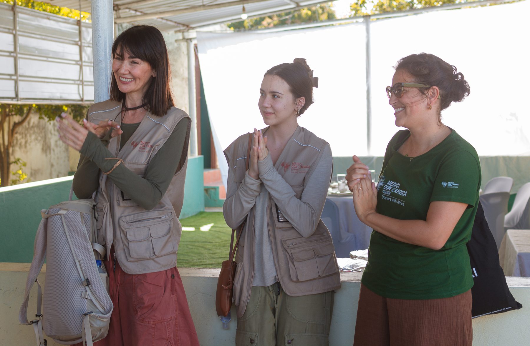 Volunteers and partners applauding together at a community event in Mozambique